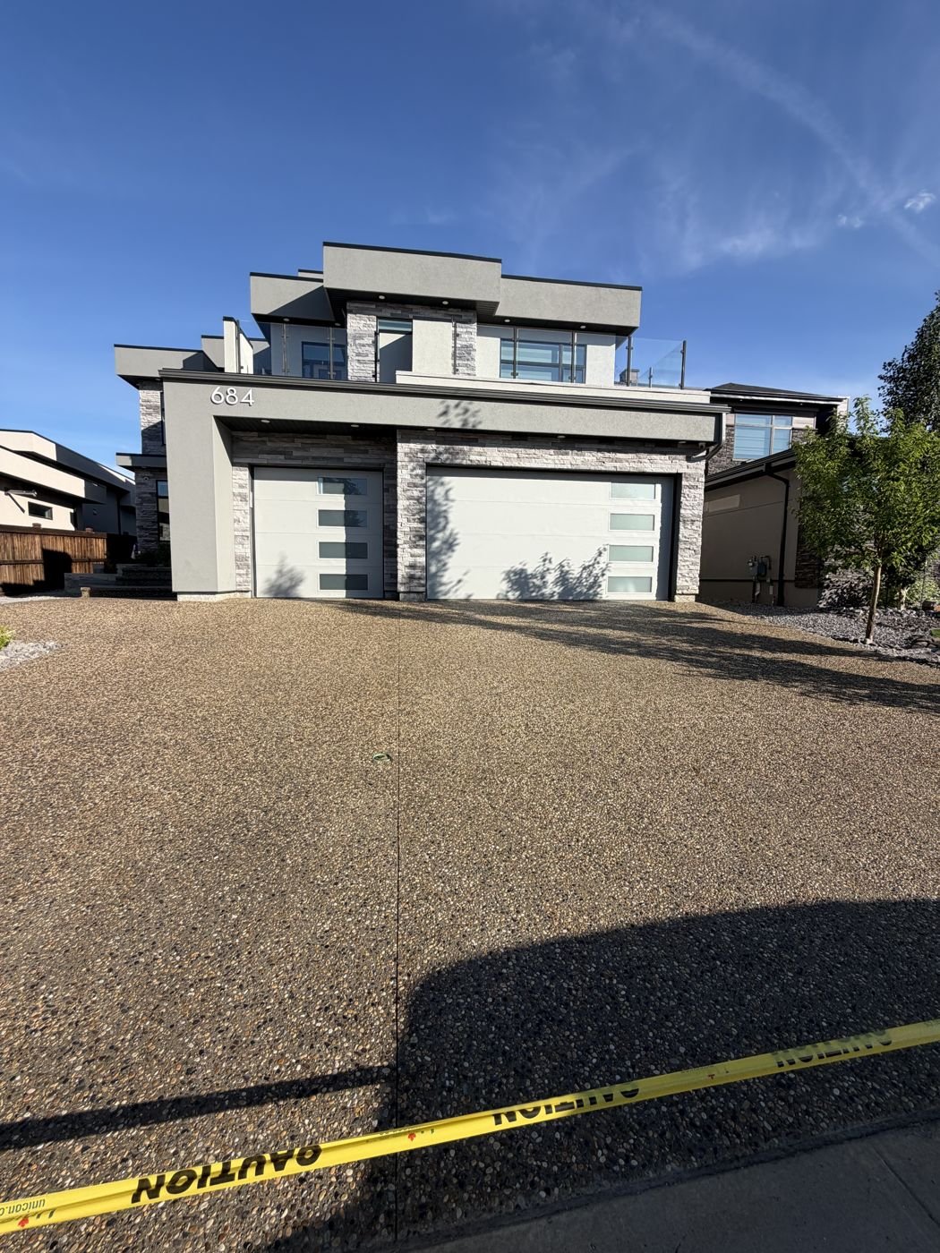 Sealed driveway roped off with caution tape while curing