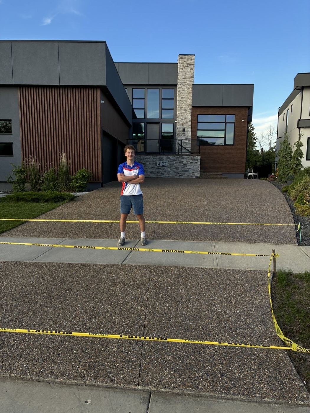 Wash & Shine Co. crew member with a freshly sealed driveway
