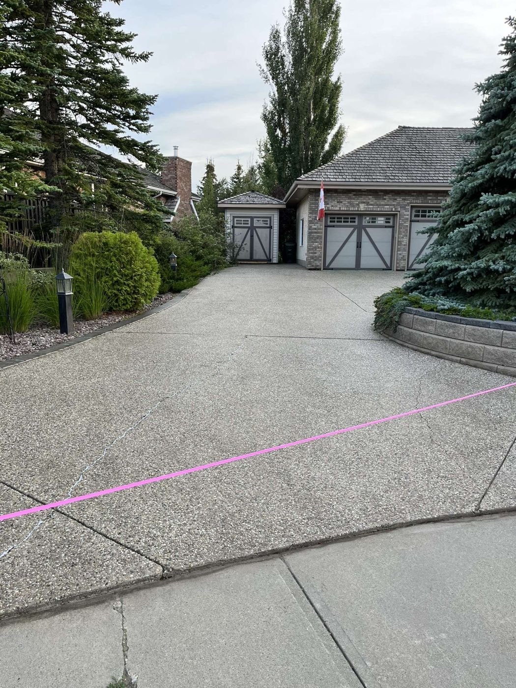 Freshly sealed driveway, treeline home