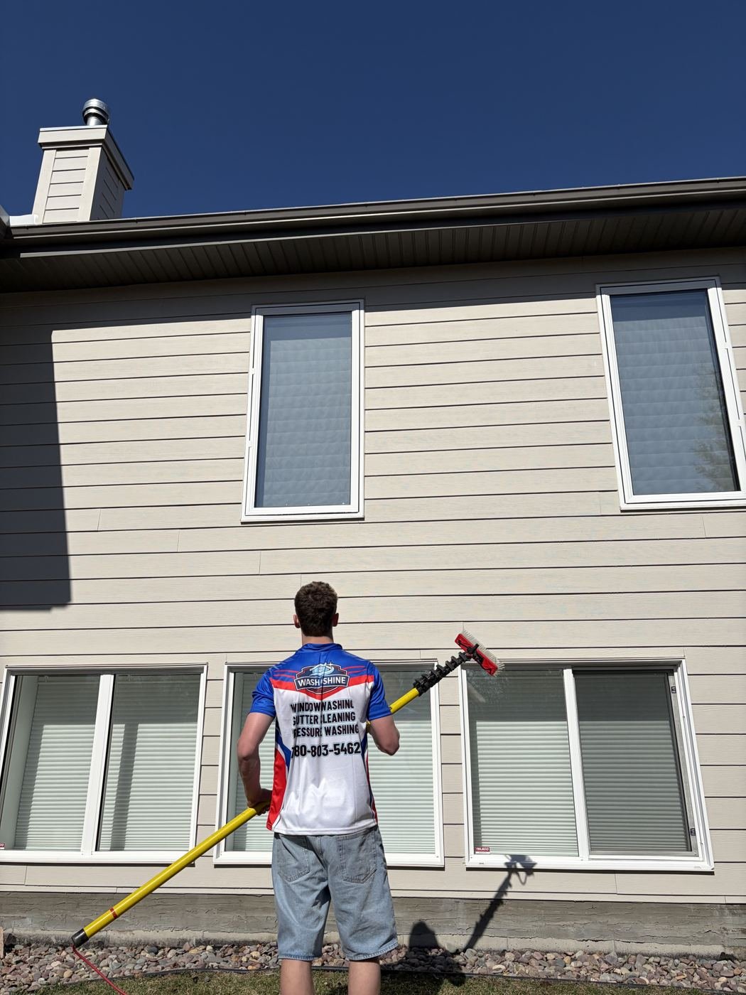 Wash & Shine Co. technician cleaning tall exterior windows